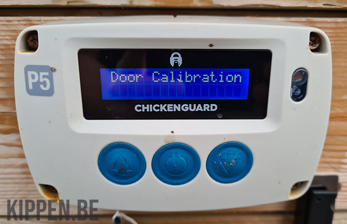 een foto van de display van de ChickenGuard met de melding van een deurkalibratie