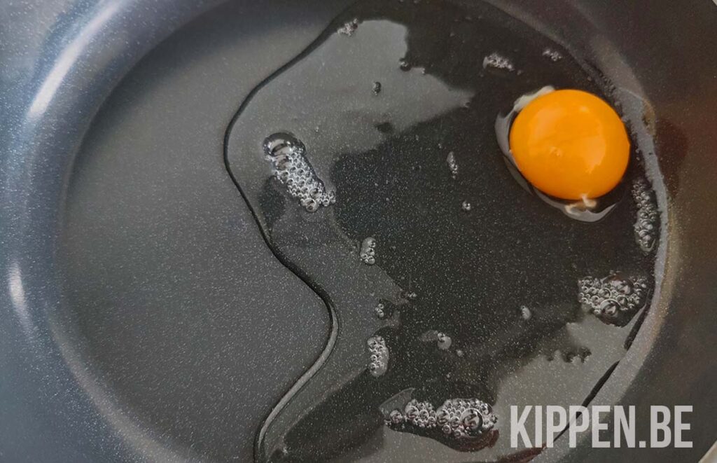 een ei met waterig eiwit in een pan
